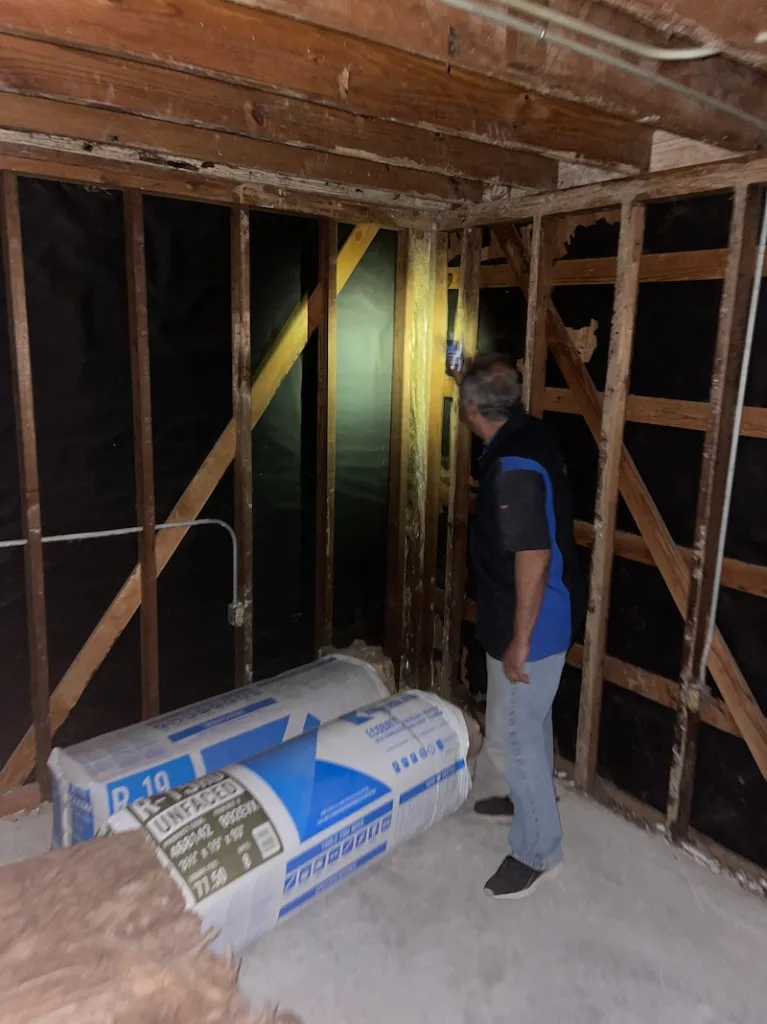 Resolve Pest and Termite owner inspecting an open wall cavity and insulation during a Houston pest and rodent inspection